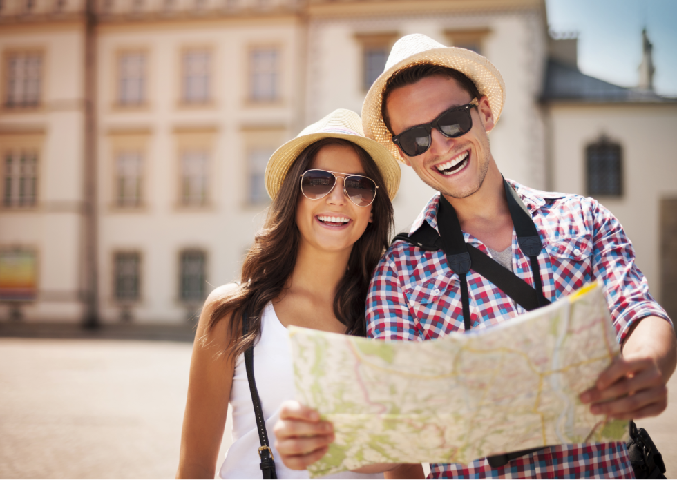 happy-tourists-couple-holding-map